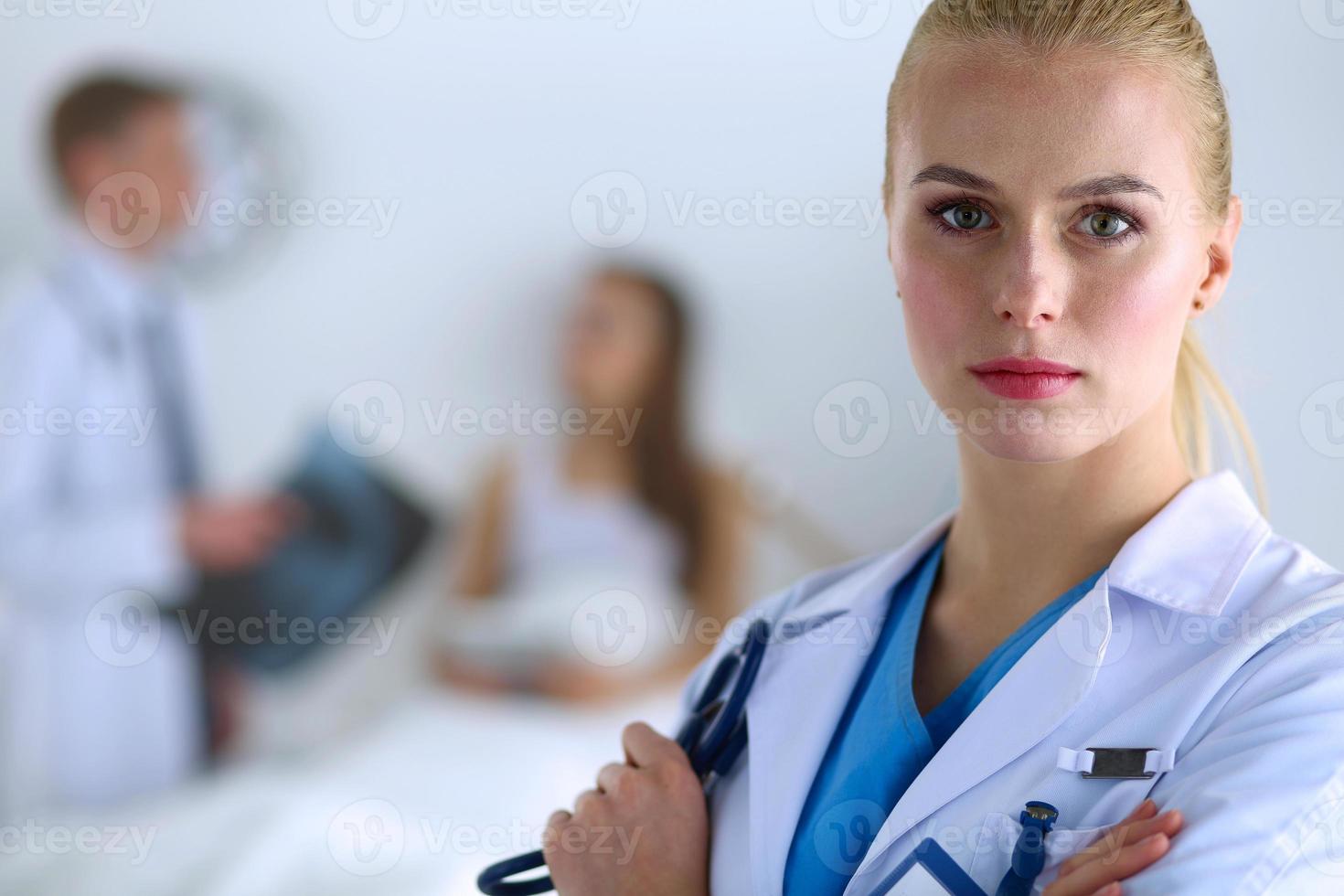 Doctora de pie con estetoscopio en el hospital foto