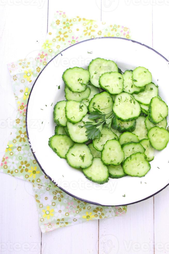 cucumber salad with dill and oil on a white plate photo