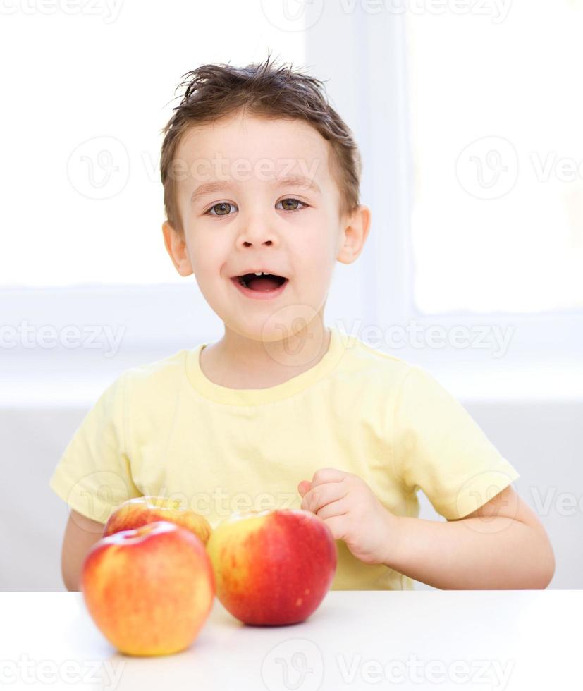 Retrato de un niño feliz con manzanas foto