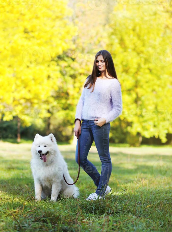 Happy woman owner and dog walking in the park photo