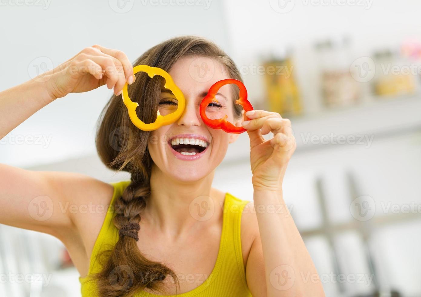 Funny young woman showing slices of bell pepper photo