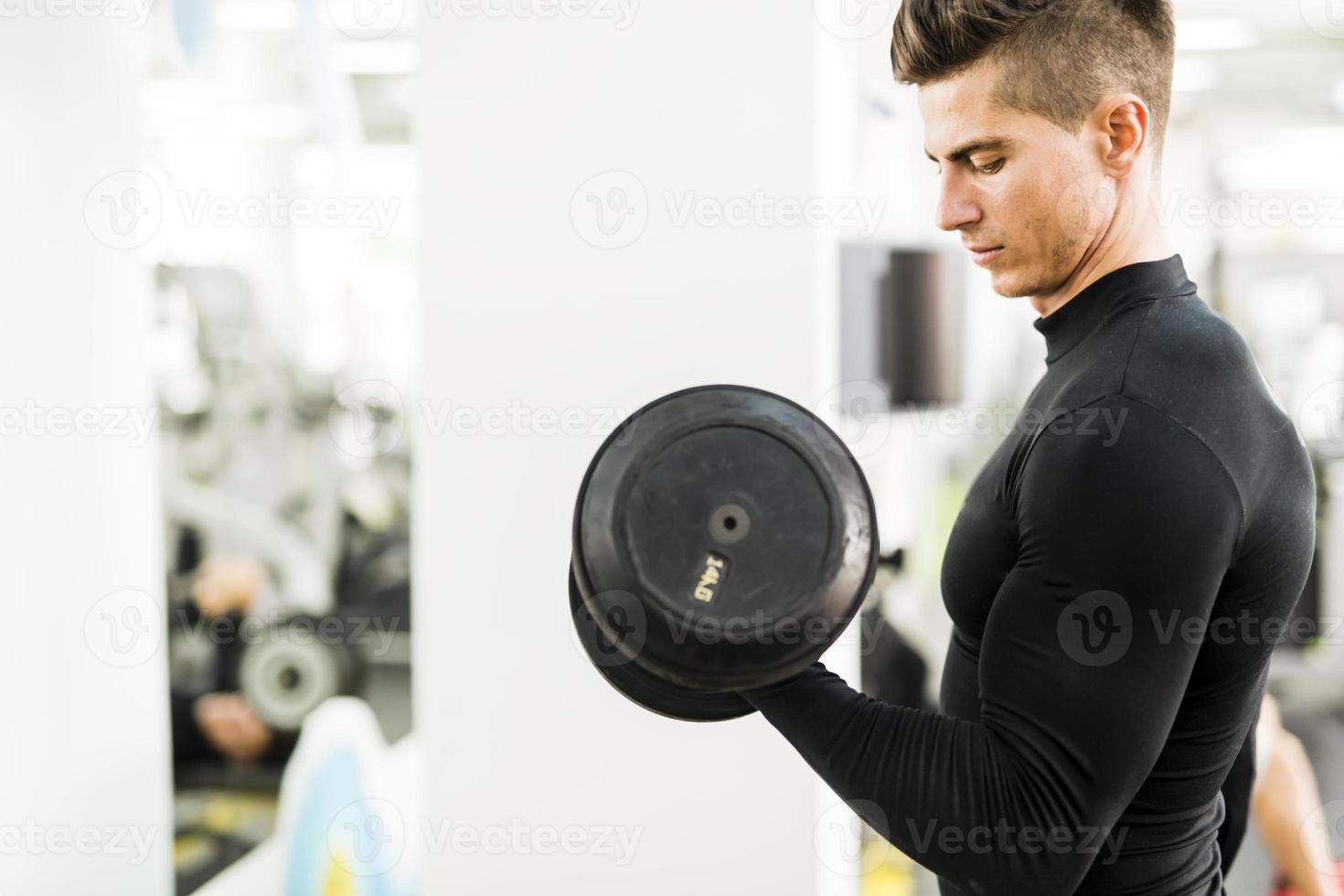 Young handsome man working out in a gym photo