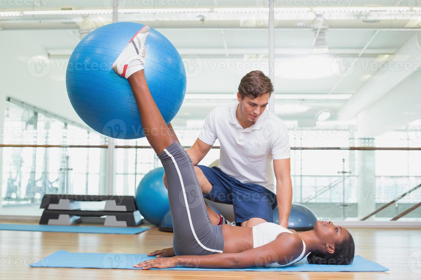 Personal trainer working with client holding exercise ball photo