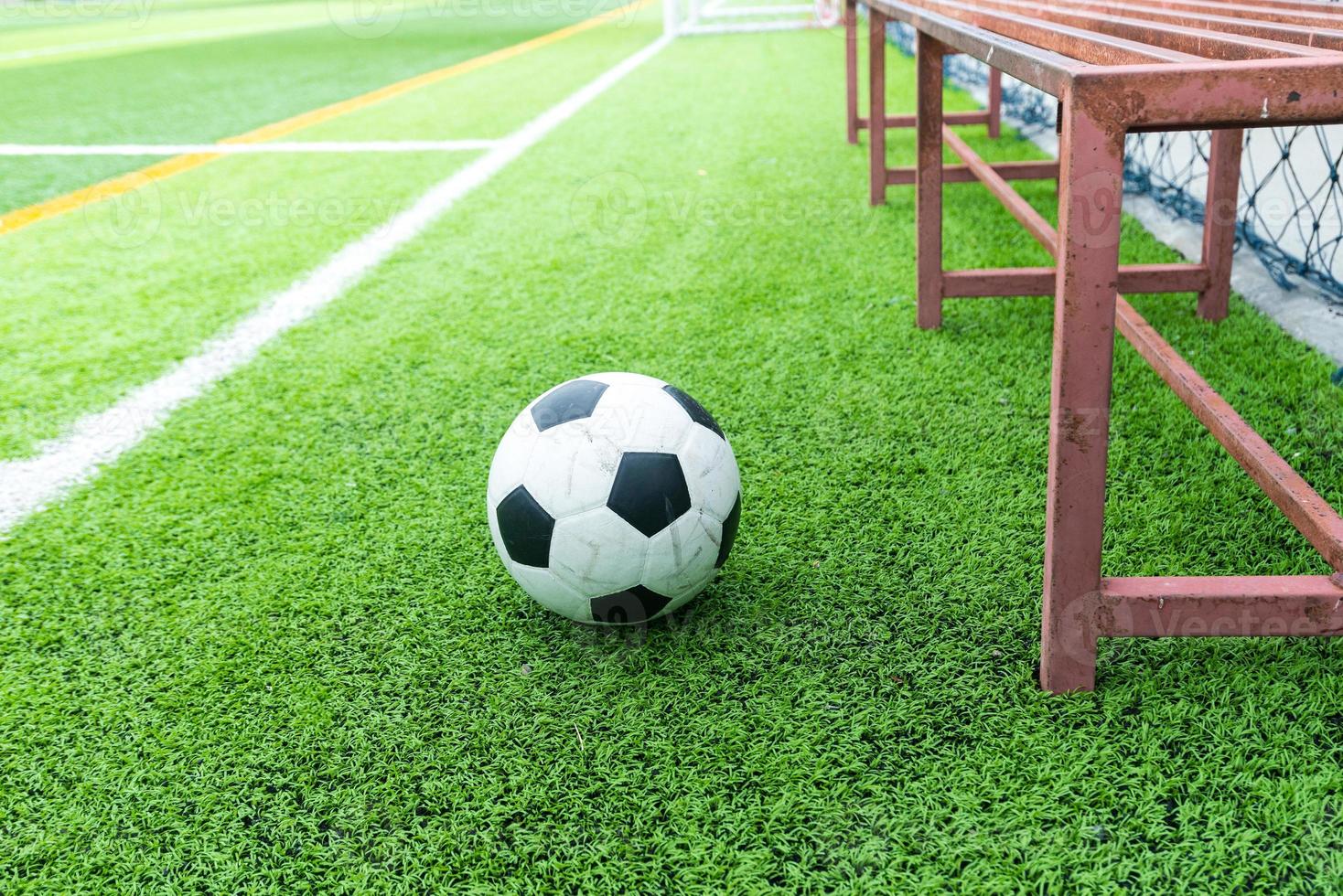 Soccer ball on field and football substitutes seats photo
