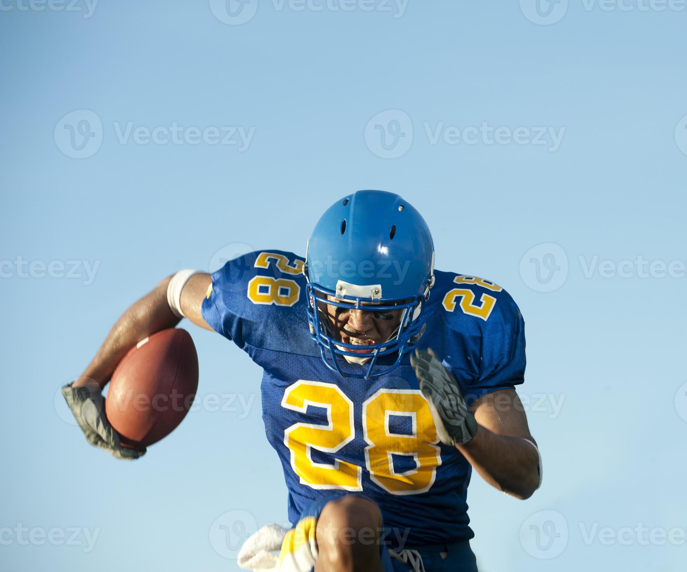 Football player holding a football while running 885209 Stock Photo at