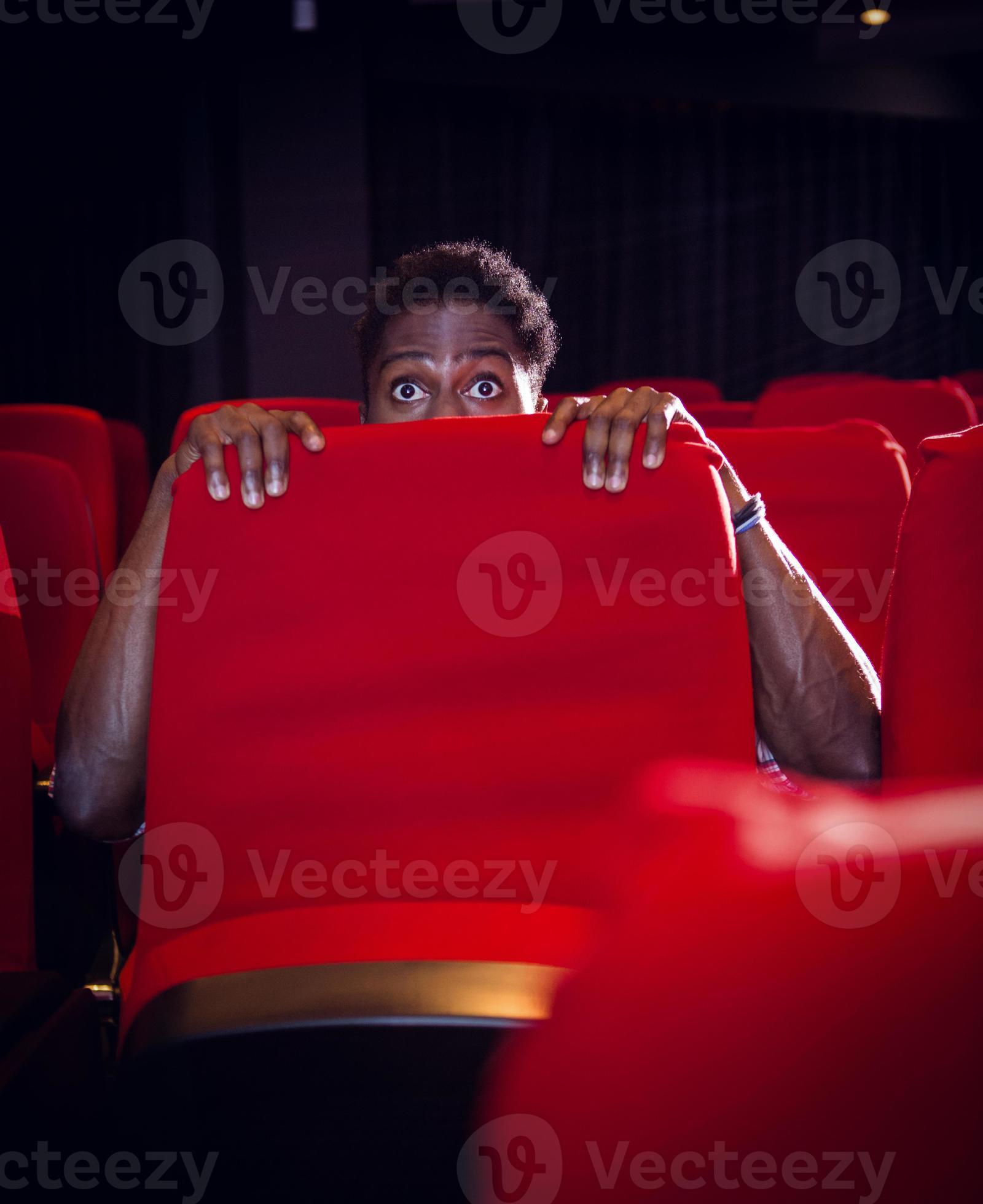 Young man watching a scary film photo