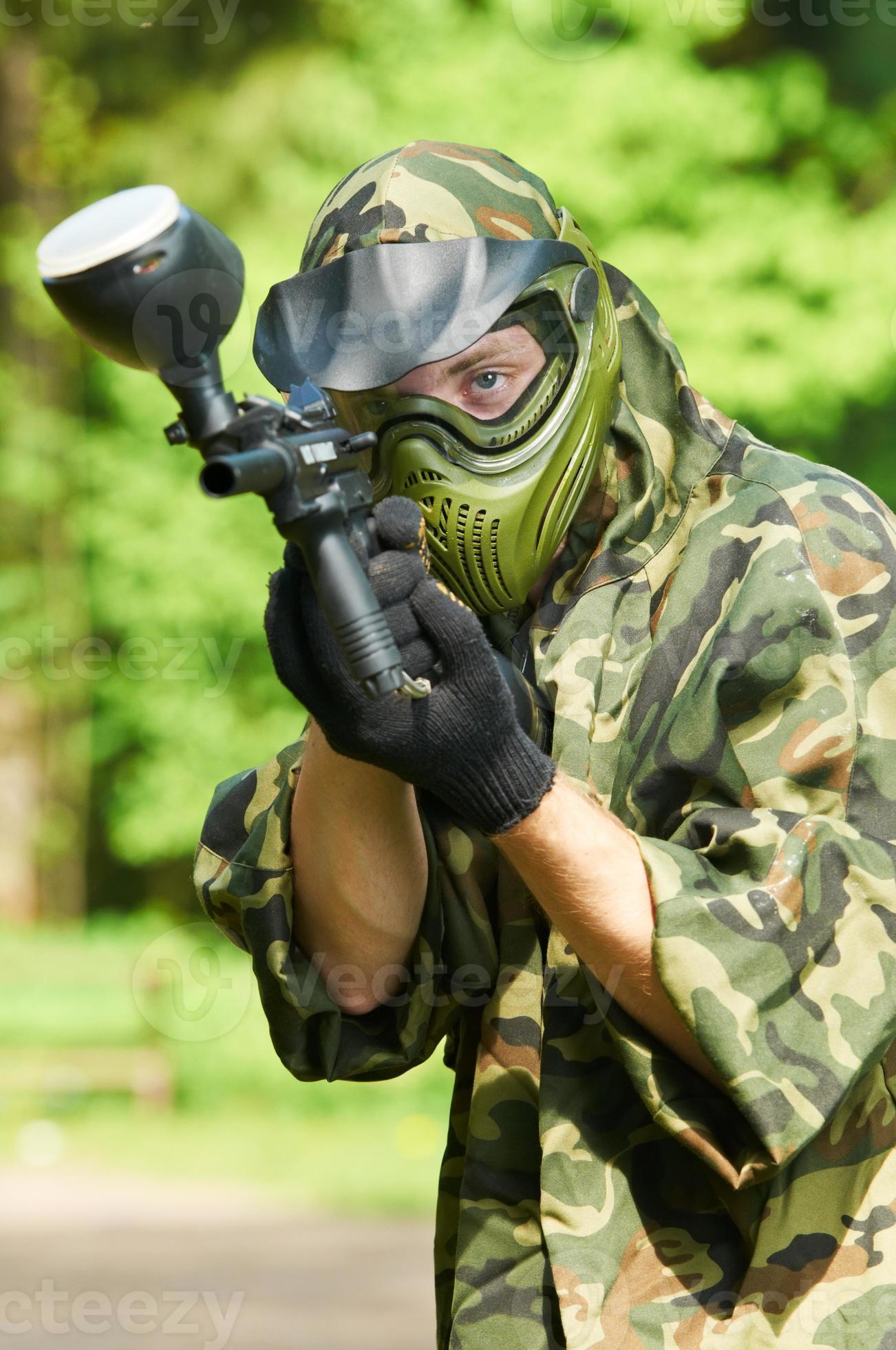 Paintball player aiming with gun 886018 Stock Photo at Vecteezy