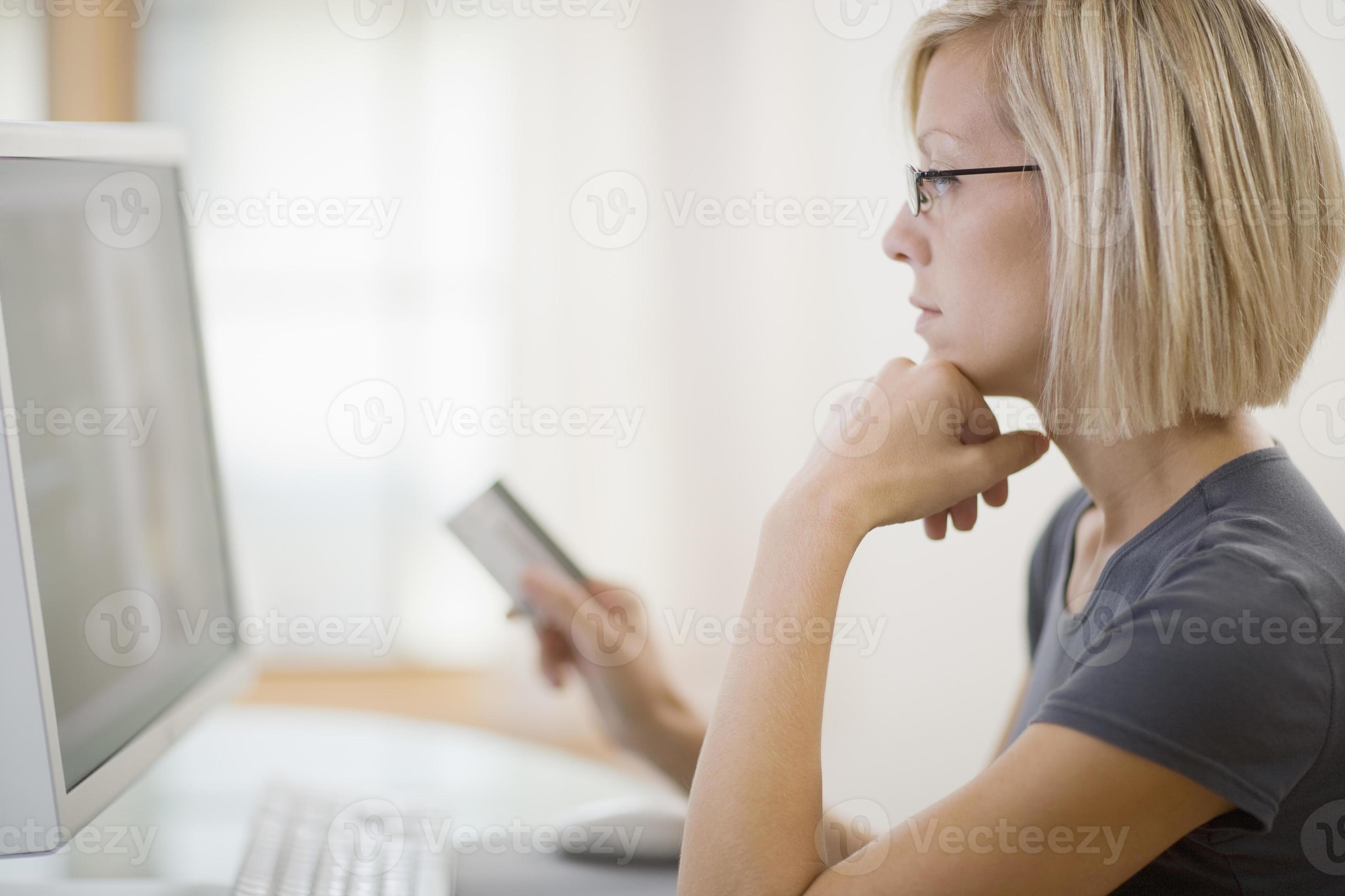 Woman using credit card and computer photo