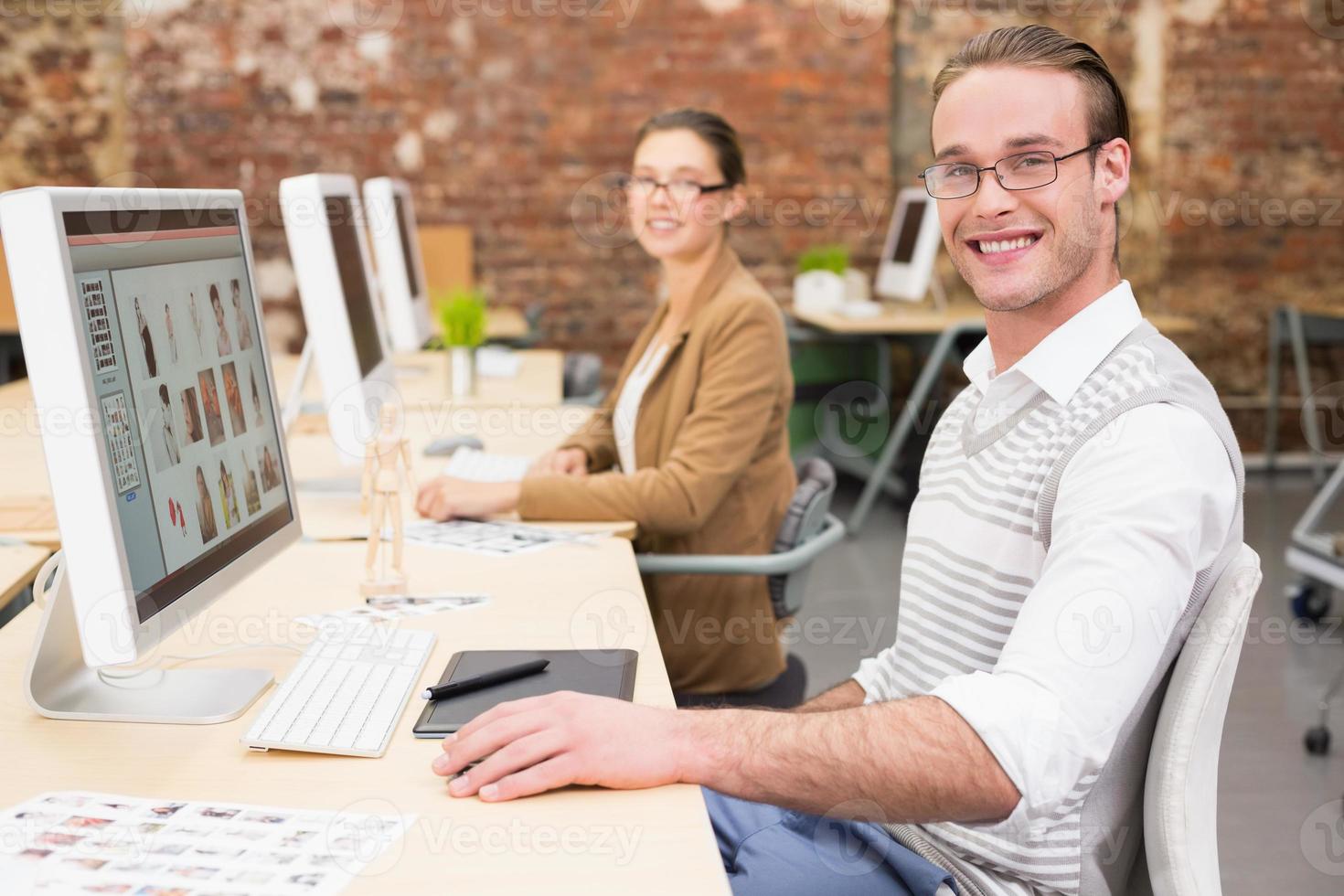 sonrientes editores de fotos usando computadoras en la oficina
