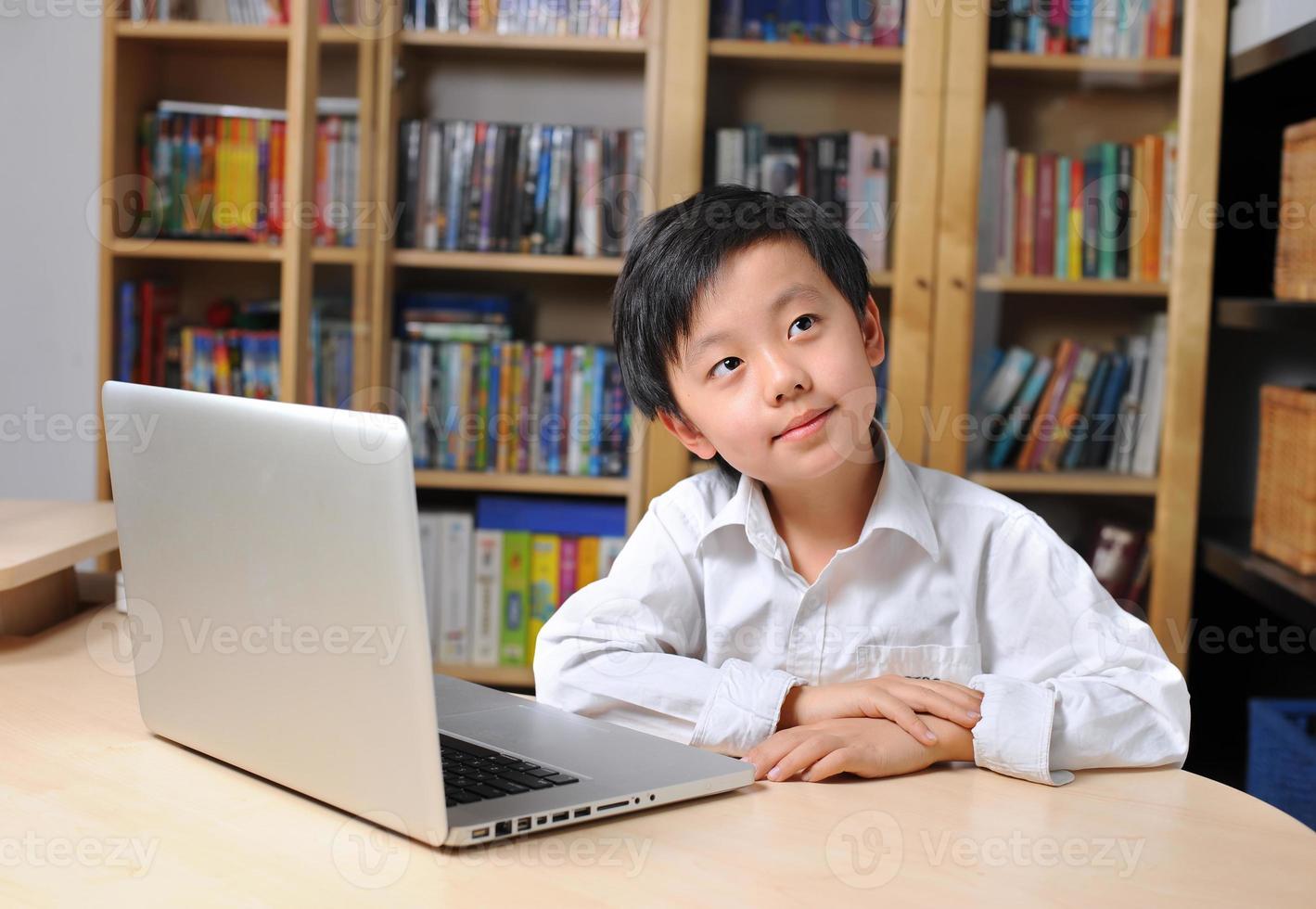 Asian boy in front of laptop computer photo