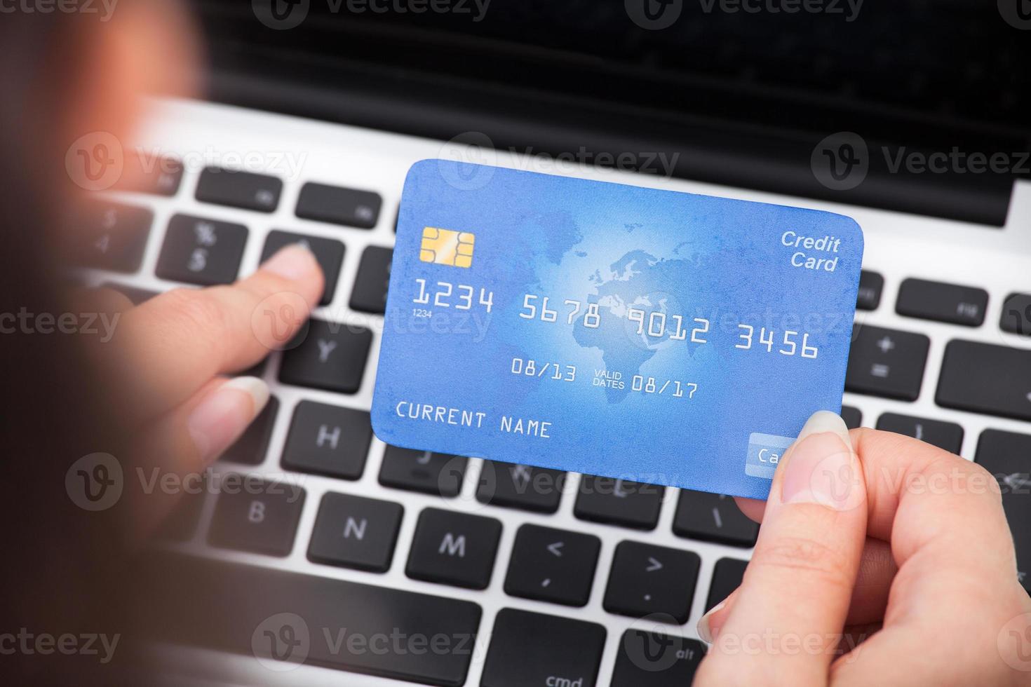 Person Holding Credit Card Using Laptop photo