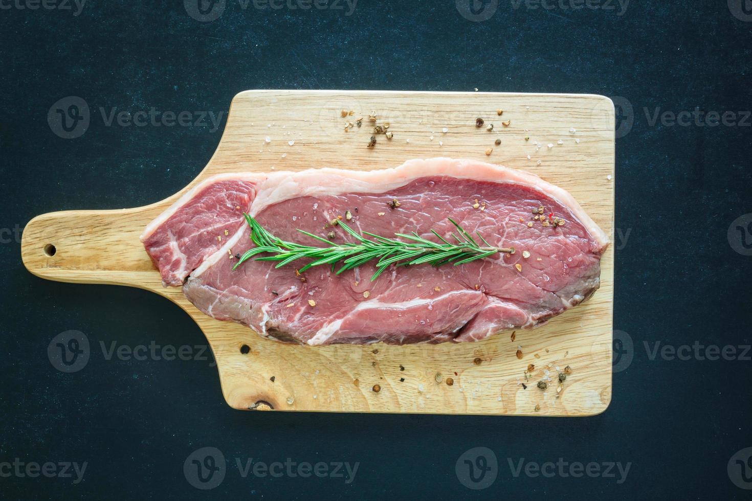 carne cruda en tabla para cortar madera foto