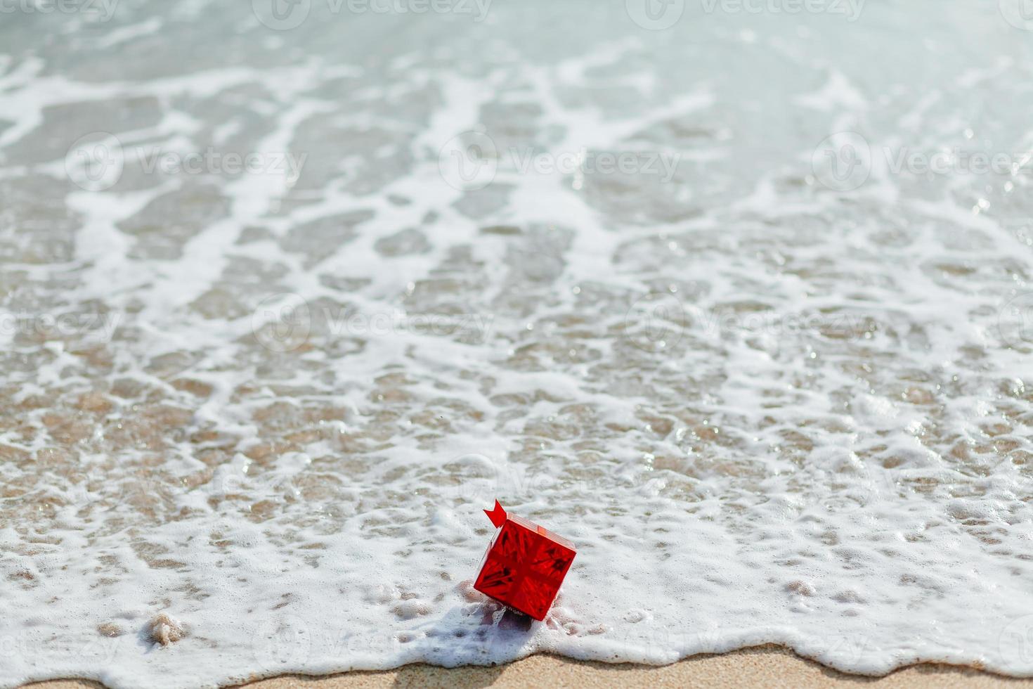 caja de regalo roja en el mar foto