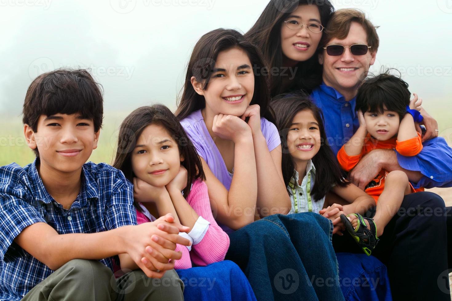familia multirracial sentado en la playa foto