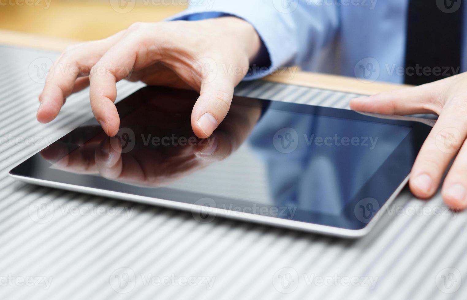 Empresario moviendo dos dedos en la pantalla táctil en tableta foto