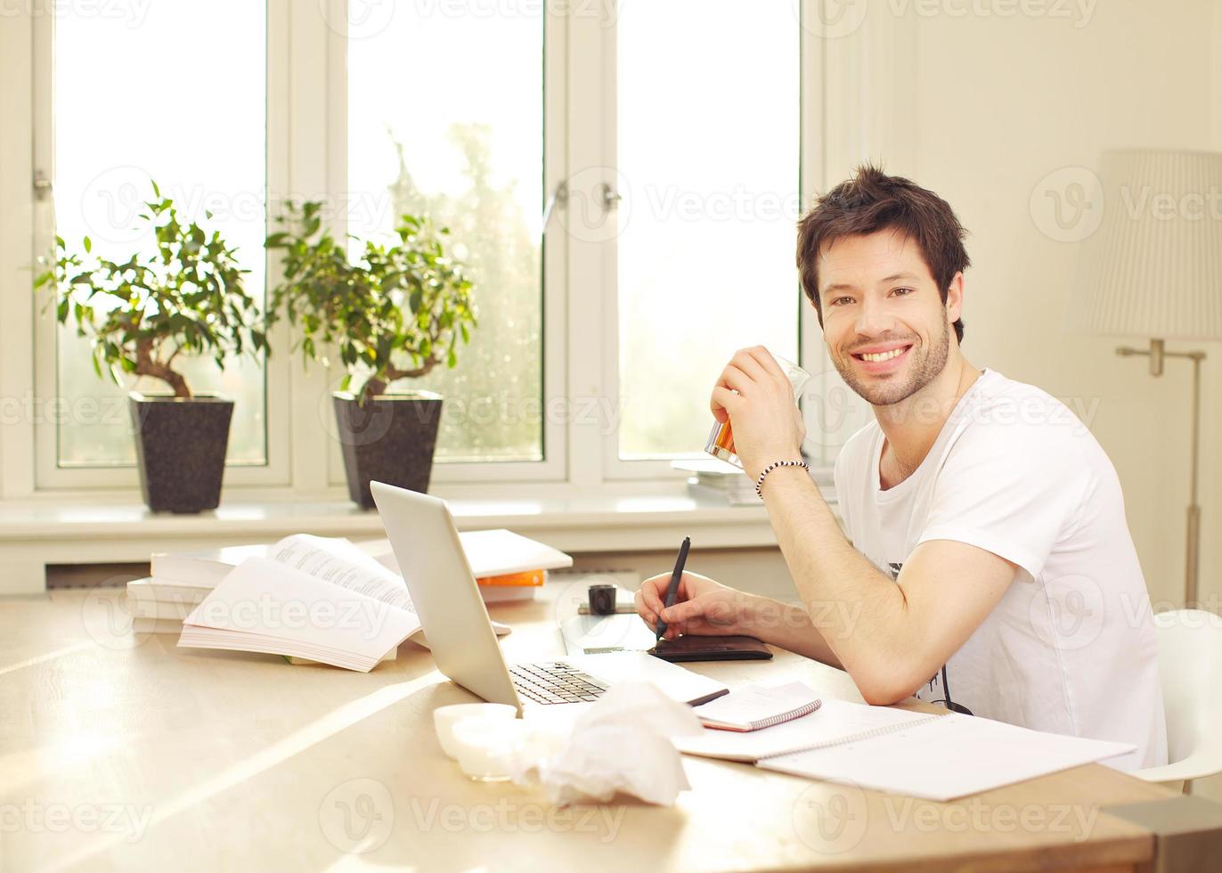 hombre sonriente confidente que trabaja en el escritorio foto