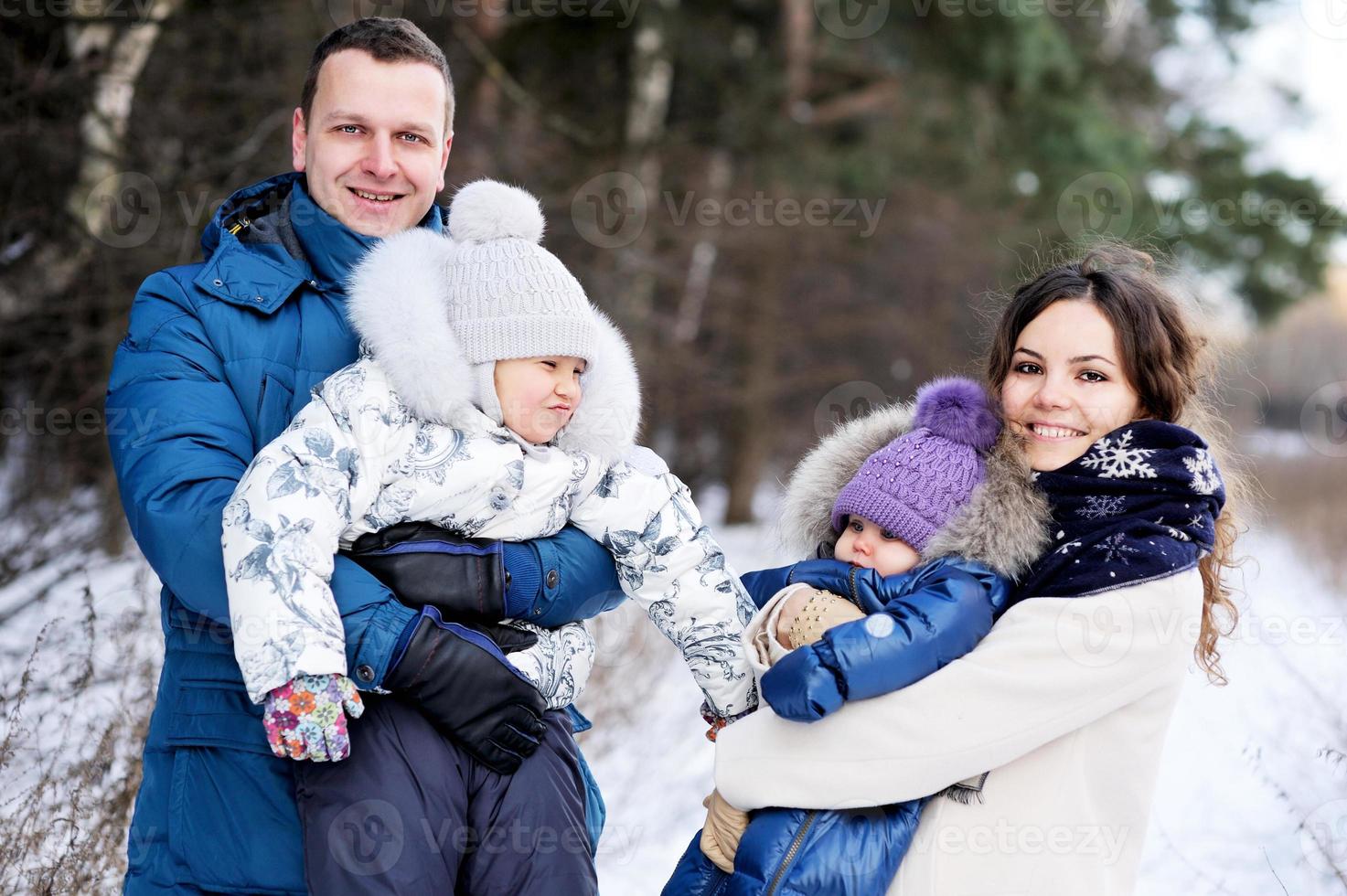 Happy family enjoying a walk in winter park photo