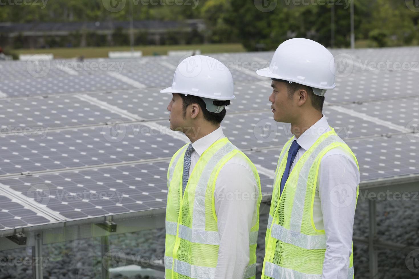 dos ingenieros asiáticos en una estación de paneles solares foto