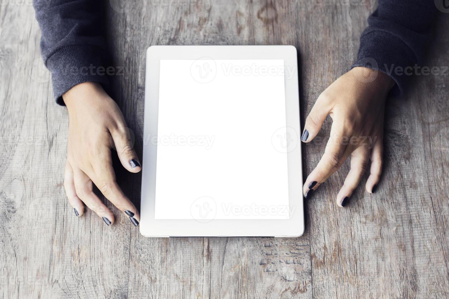 Girl hands with blank digital tablet on a wooden table photo
