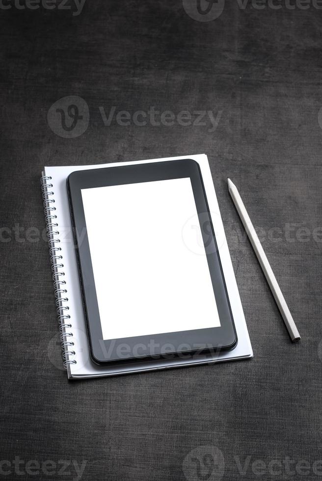 White blank screen on the tablet pc on wooden background photo