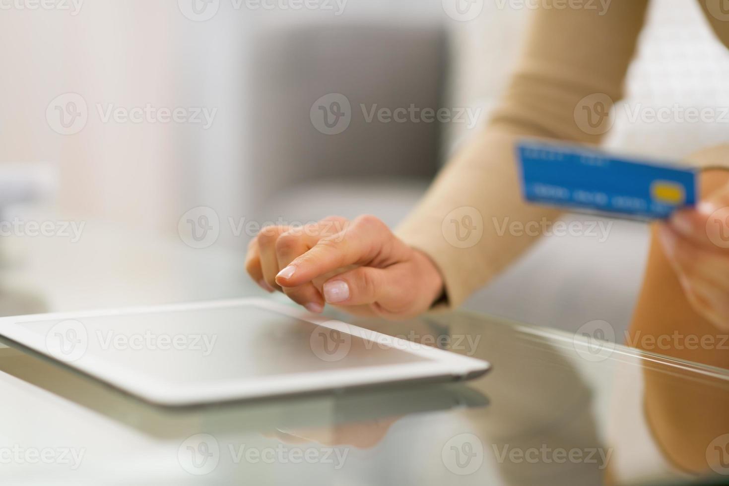 closeup on young woman with credit card using tablet pc photo