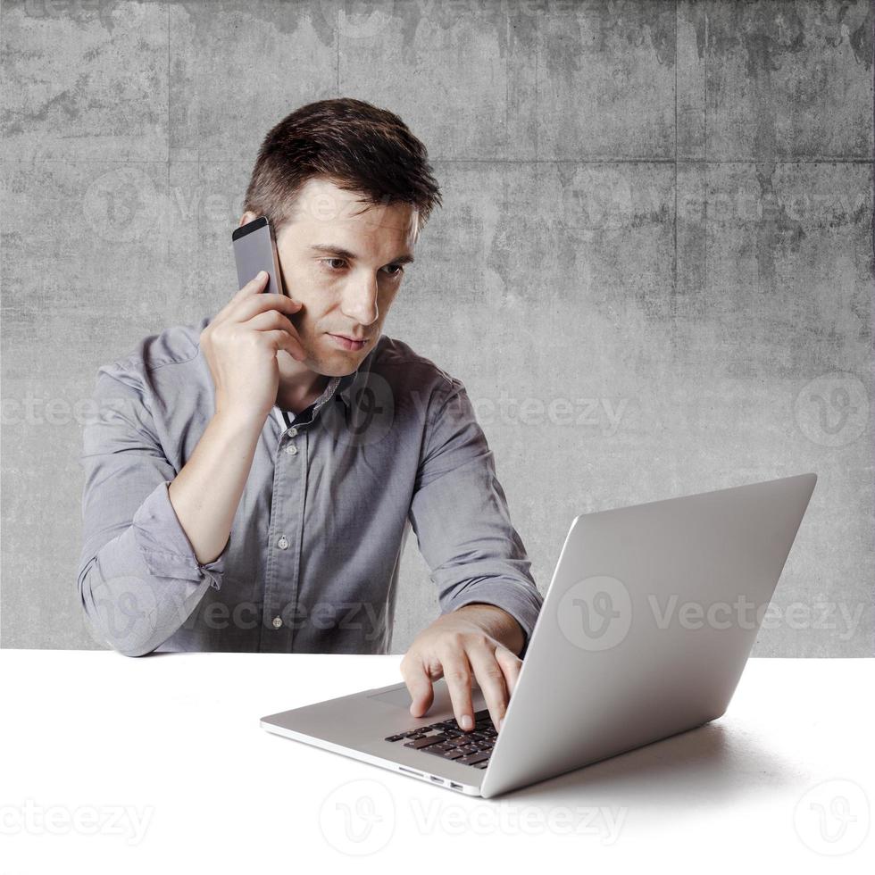 Cerrar imagen de hombre de negocios multitarea usando una computadora portátil foto