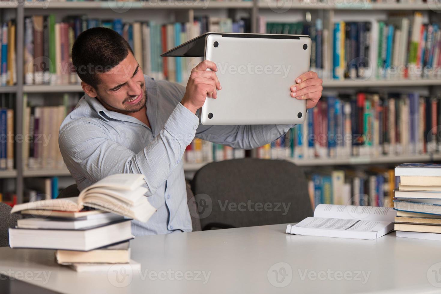 estudiante enojado quiere romper su computadora portátil foto
