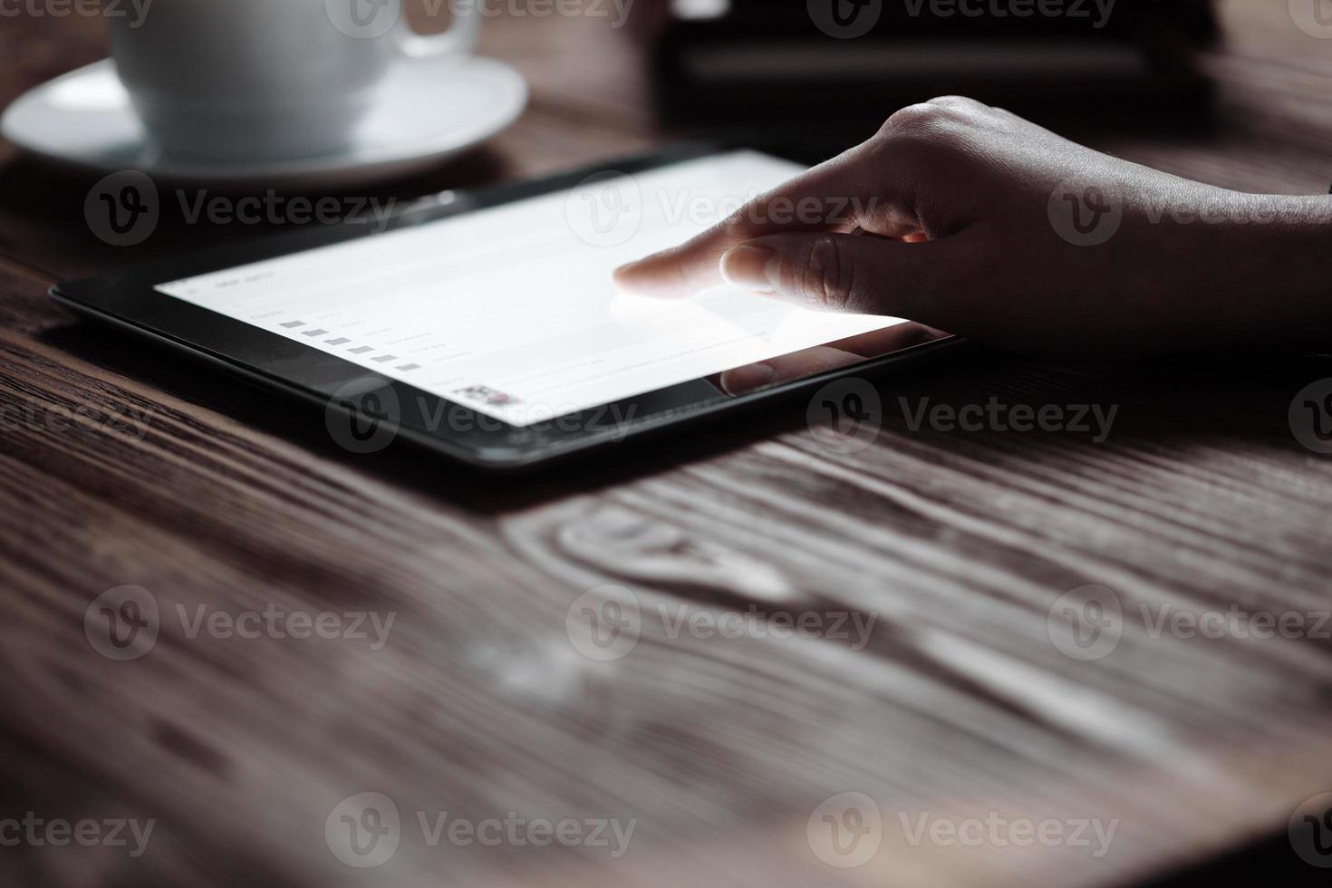 mujer mano presiona en la tableta digital de pantalla foto