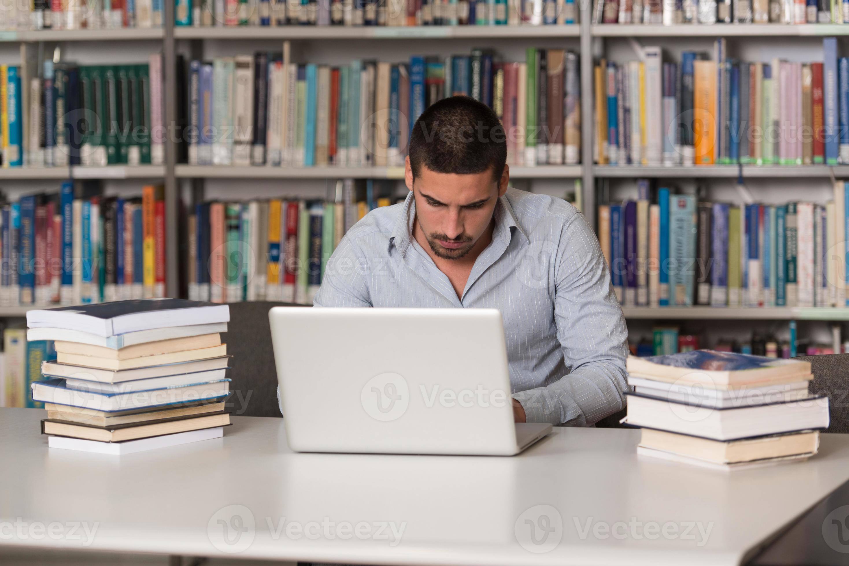 joven usando laptop en la biblioteca foto