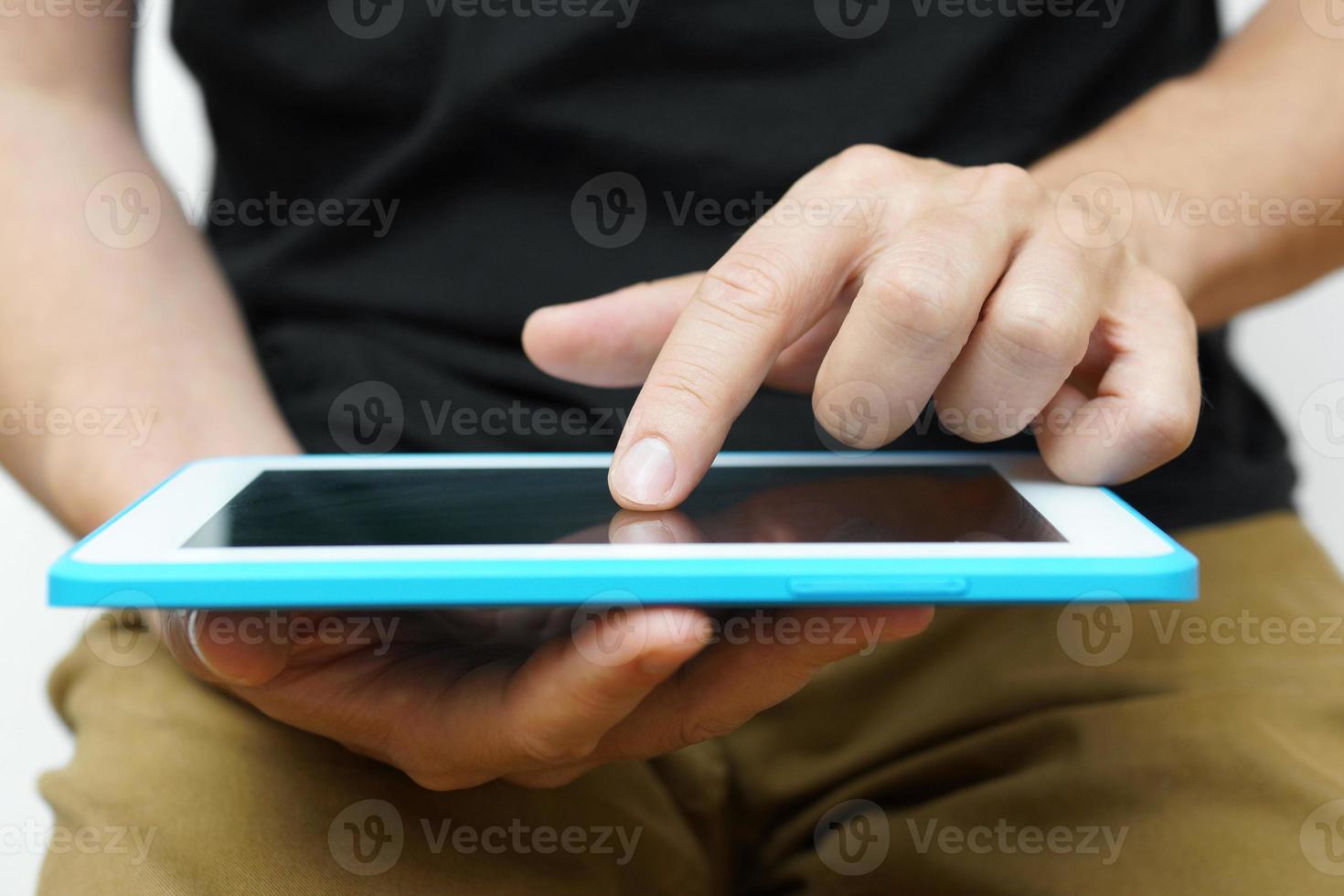 hombre trabajando en un tablet pc con su mano foto