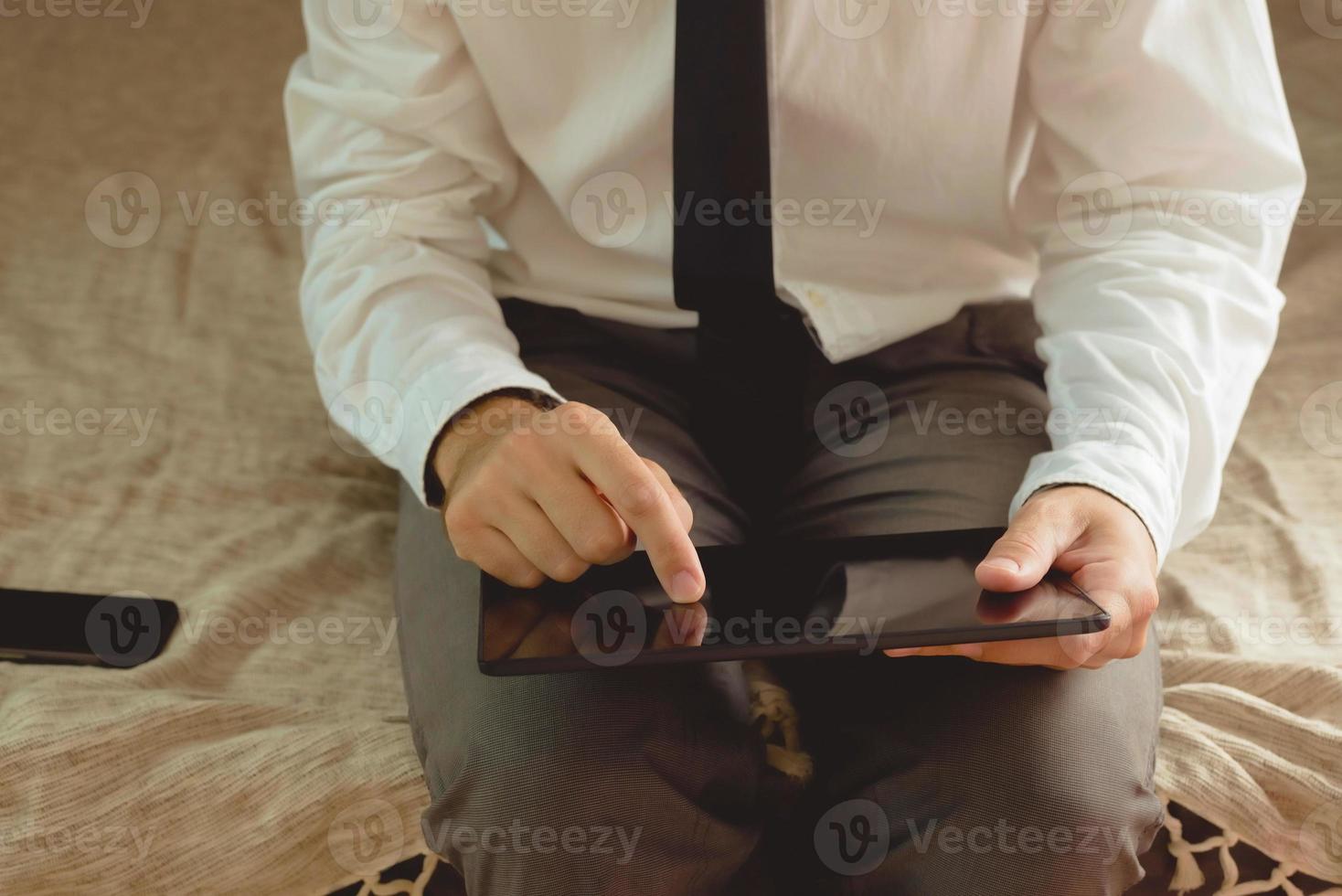 Lonely businessman in hotel room sitting on the bed photo