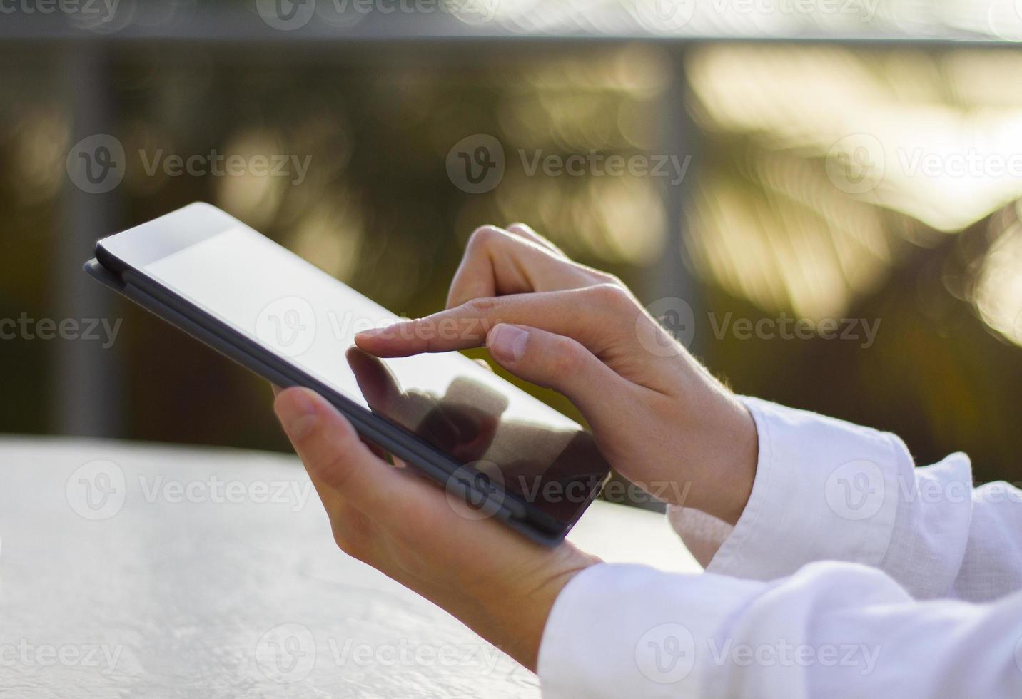man clicks on a digital tablet at sunrise photo