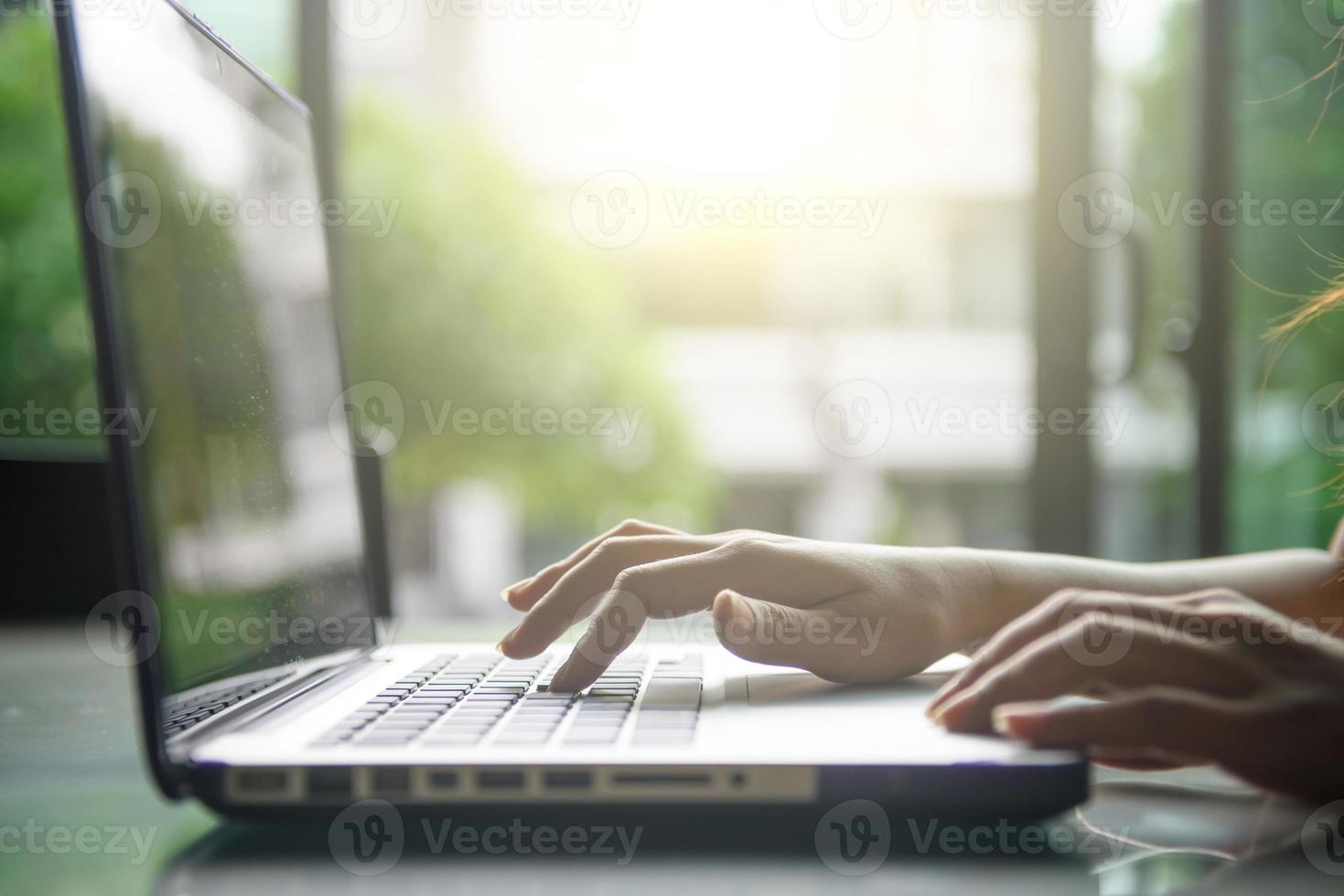 imagen recortada de una mujer que trabaja en la computadora portátil foto
