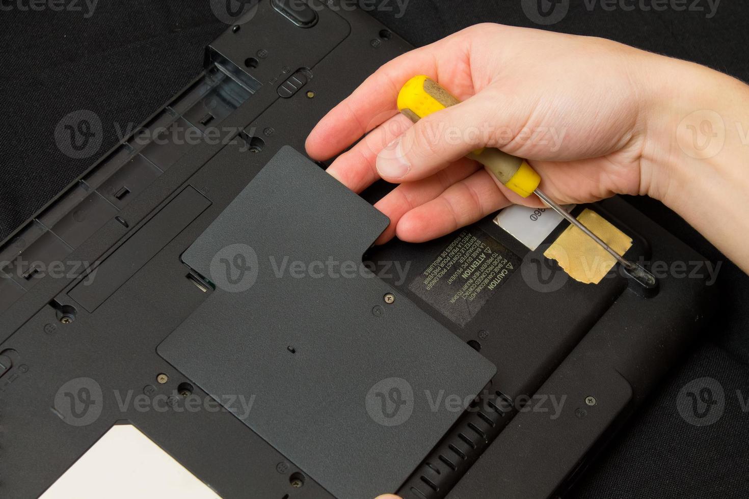 man opens a laptop with screwdriver 896146 Stock Photo at Vecteezy