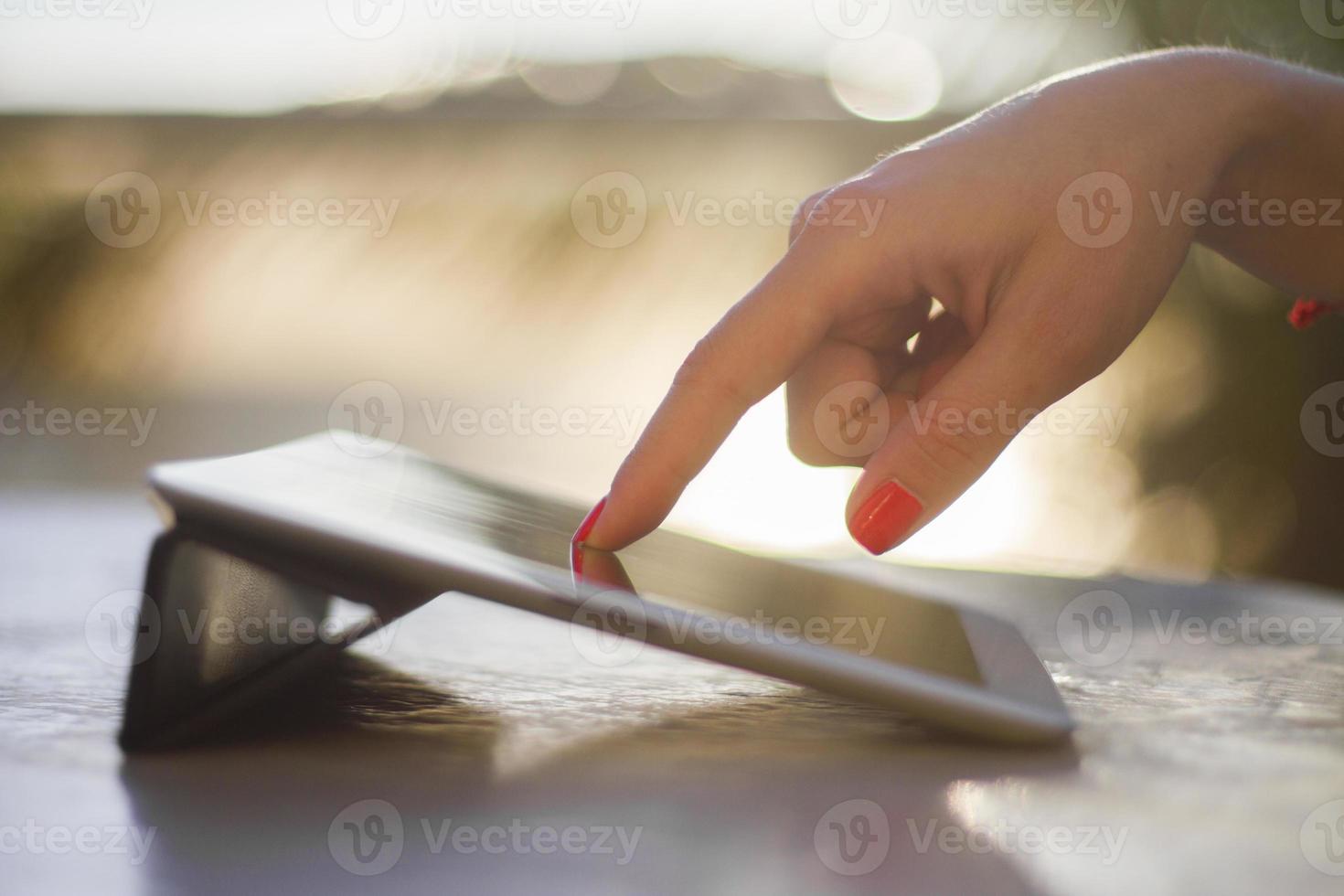 woman hand pushing on a digital tablet photo