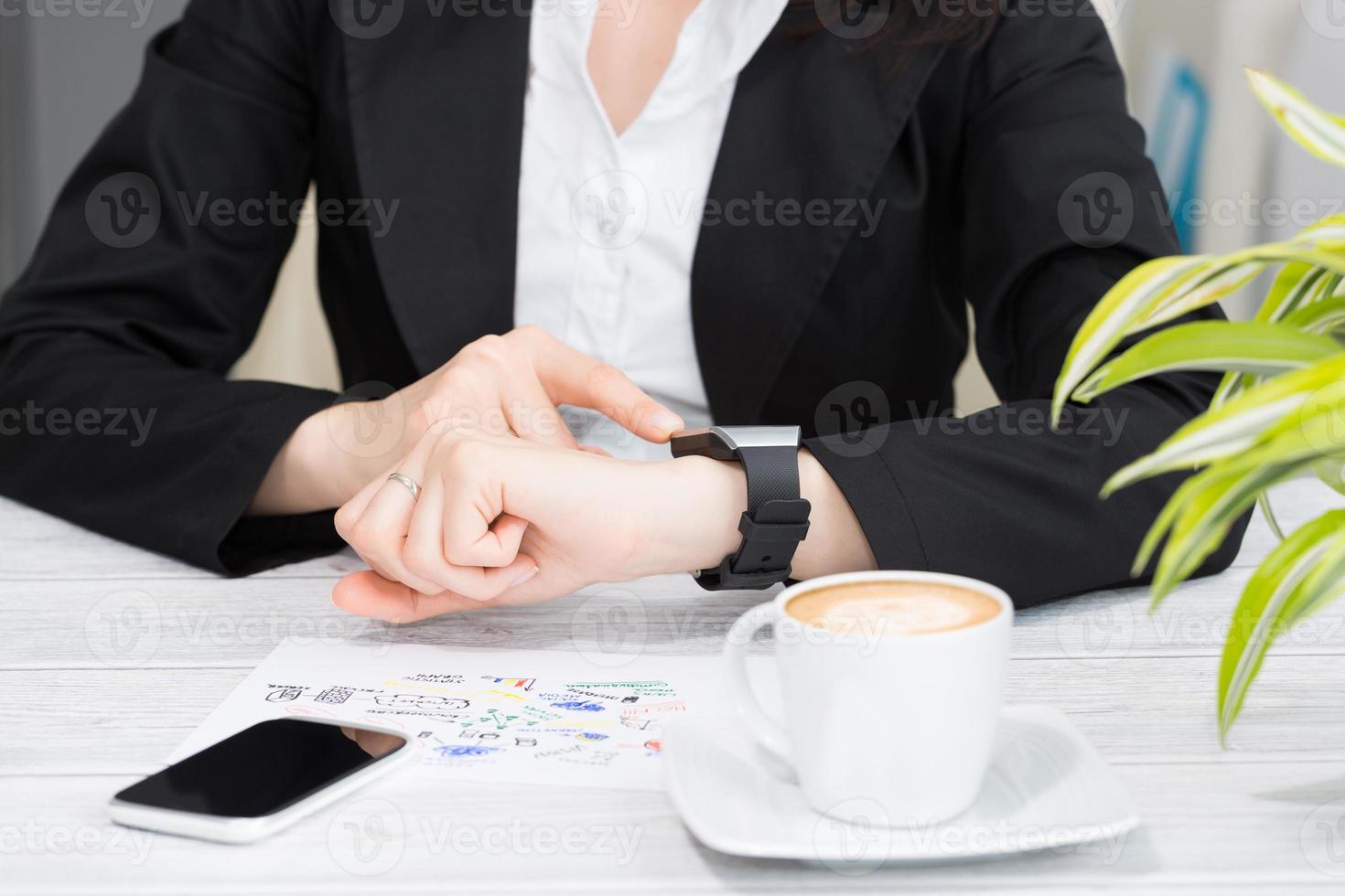 Businesswoman uses smart watch and phone. photo