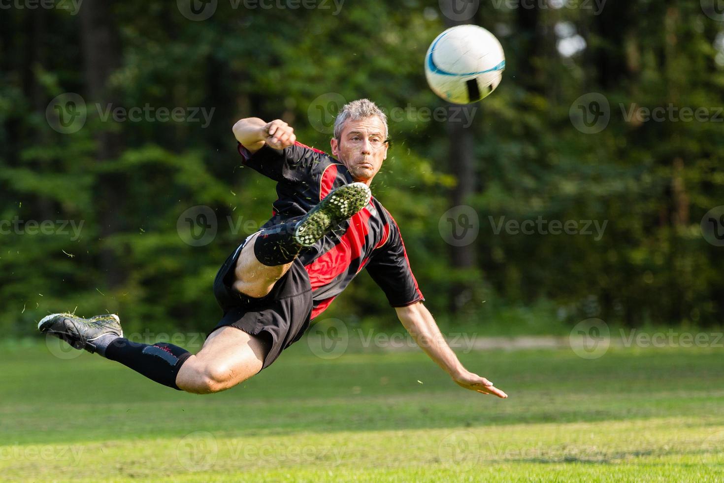 soccer player in a bicycle kick photo