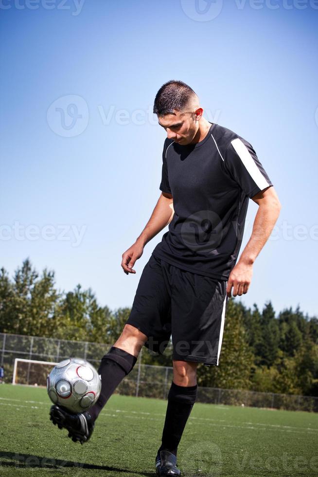 Jugador de fútbol o fútbol hispano pateando una pelota foto