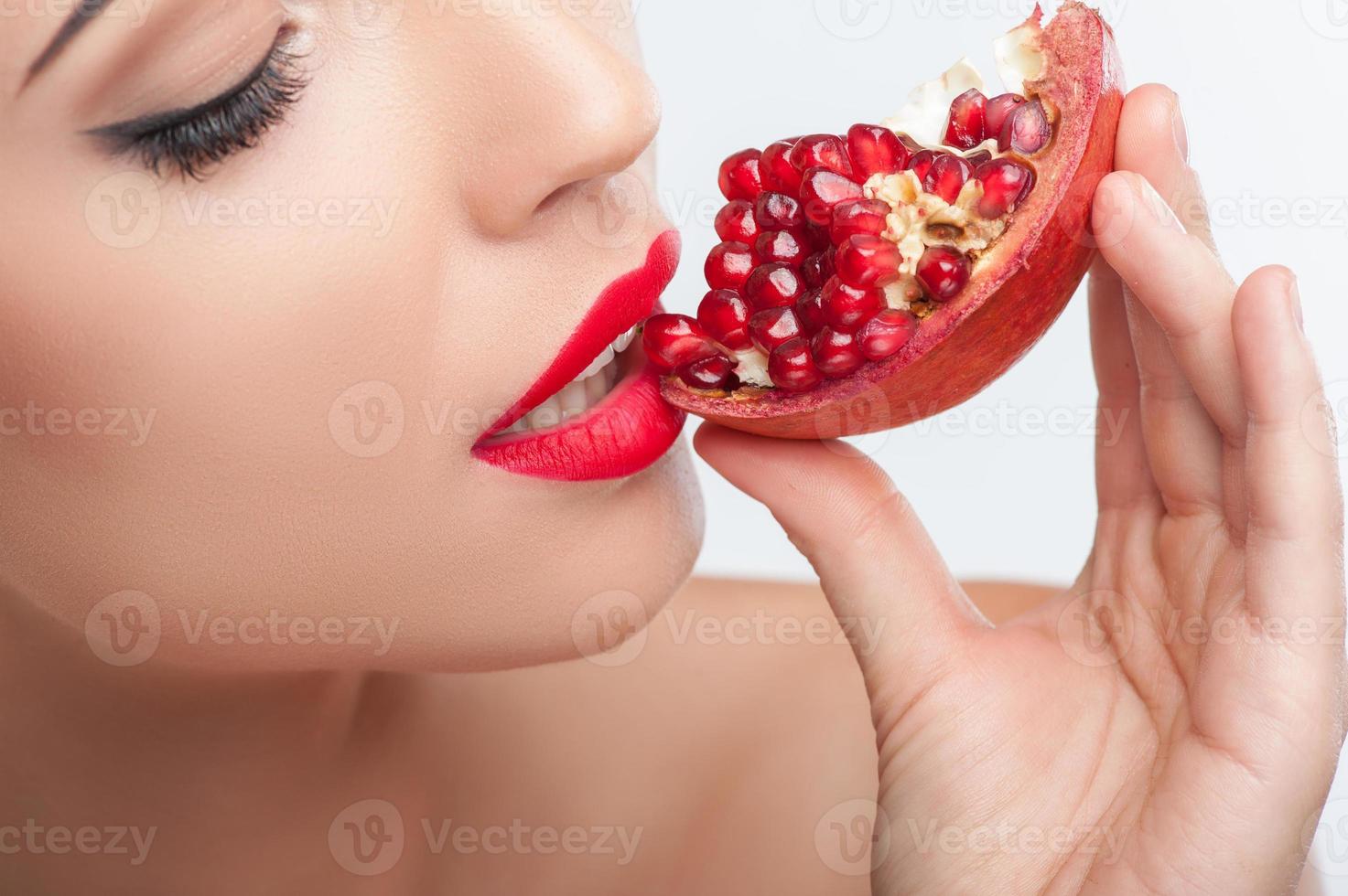 Attractive young woman is enjoying healthy fruit photo