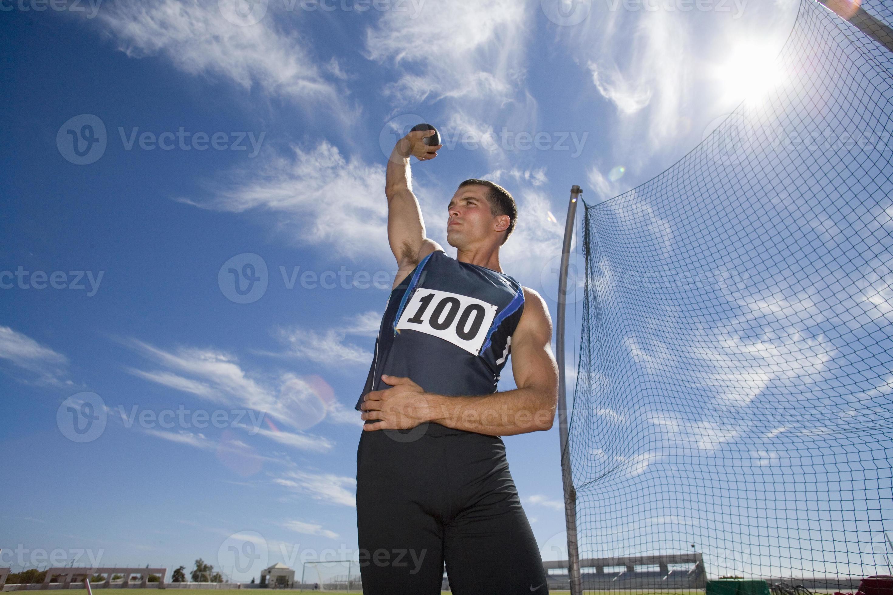 Male athlete preparing to throw shot put ball (lens flare) 901997 Stock