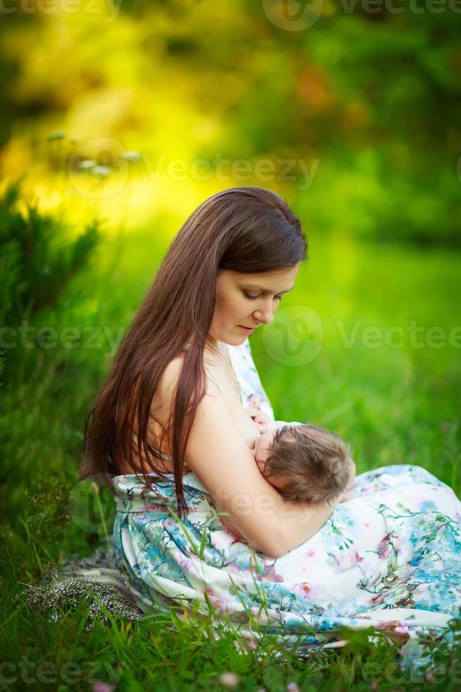 mamá alimenta al bebé, amamantando, verano foto