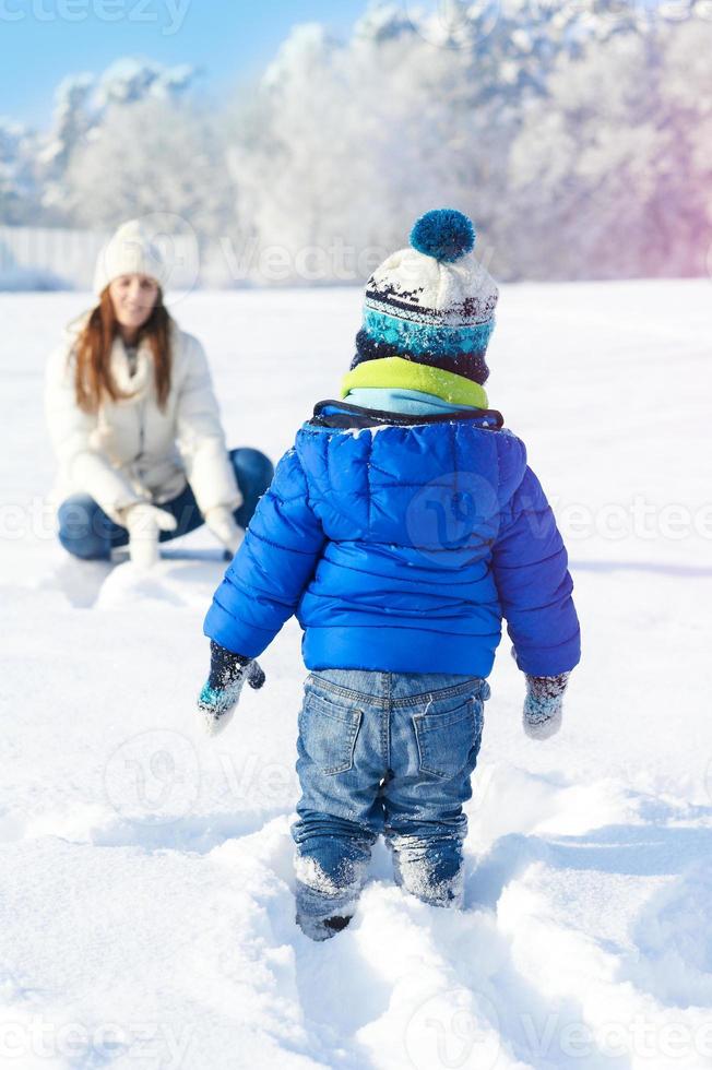 Babyboy hijo y madre son felices juntos, día nevado de invierno foto