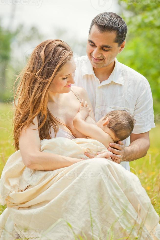 Mother Breastfeeding Baby with Husband in Romantic Outdoors 903033 Stock Photo at Vecteezy