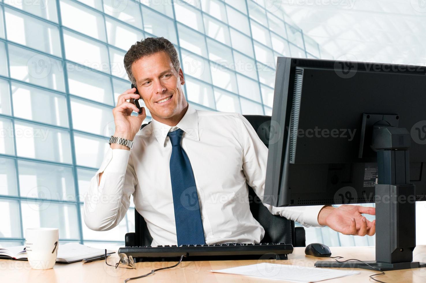 empresario en la oficina hablando por teléfono foto