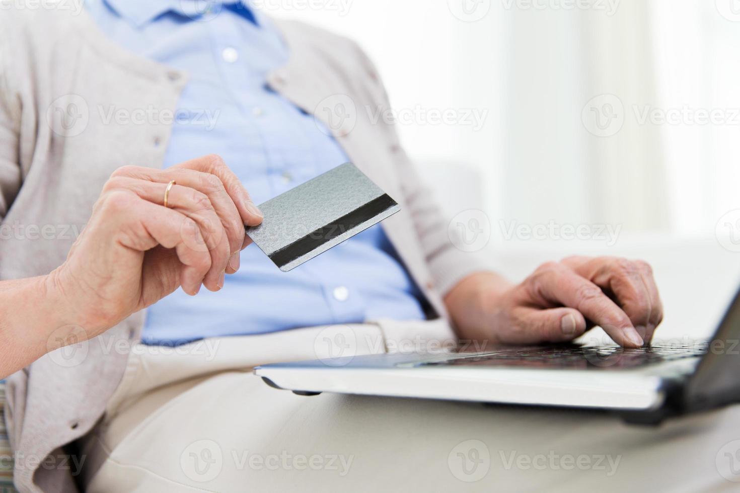 senior woman with laptop and credit card at home photo