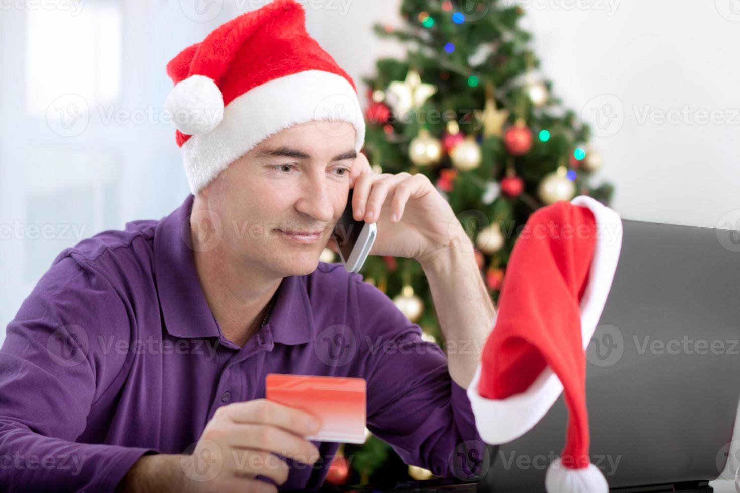 sonriente hombre de mediana edad compra regalos en línea para navidad foto