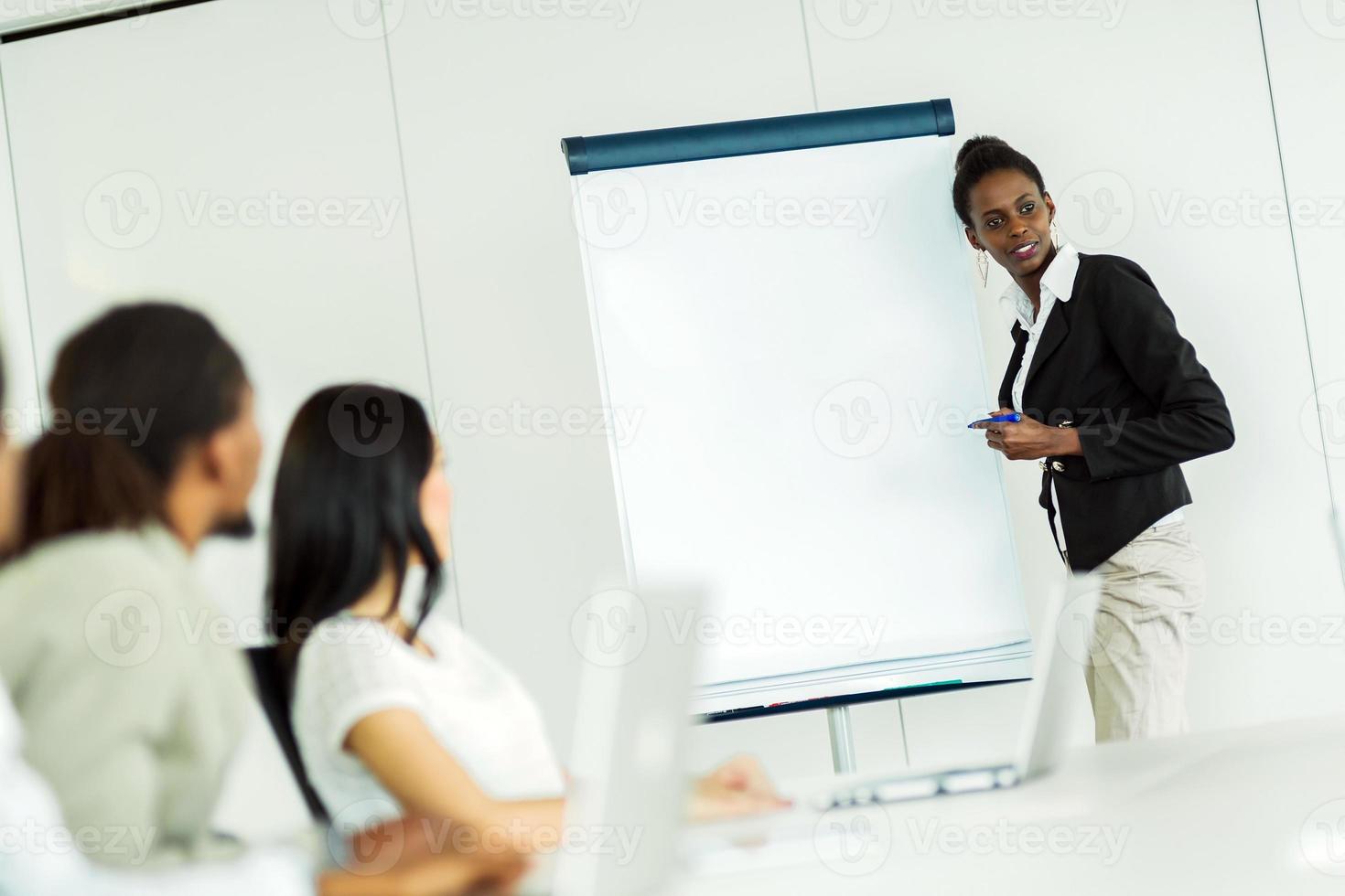 Young business people sitting at a conference table and learning photo