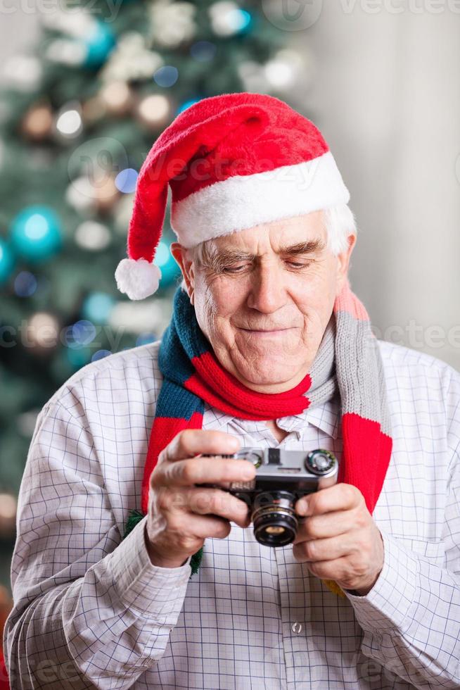 Senior man taking photo on Christmas background