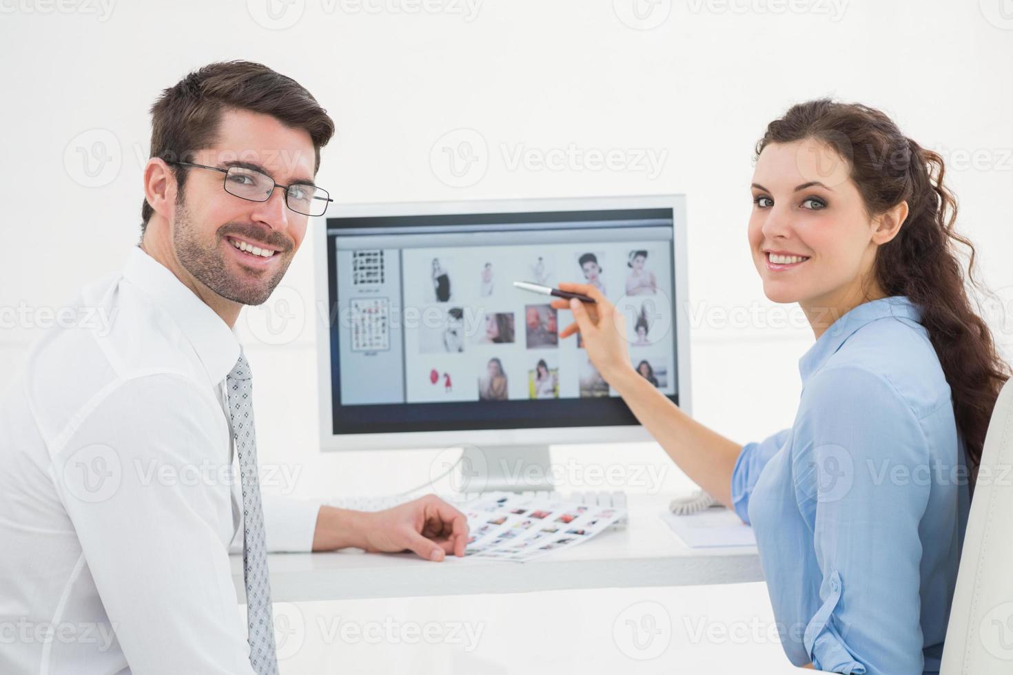 Portrait of smiling teamwork using computer photo