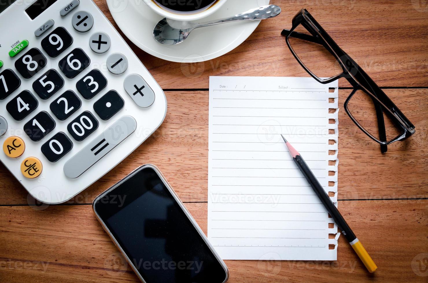 cuaderno en blanco y calculadora con teléfono inteligente foto